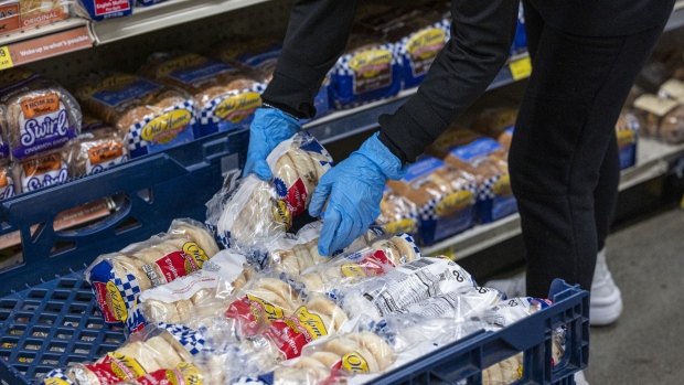 A worker stocks bread inside a grocery store in San Francisco, California, U.S., on Monday, May 2, 2022. U.S. inflation-adjusted consumer spending rose in March despite intense price pressures, indicating households still have solid appetites and wherewithal for shopping.