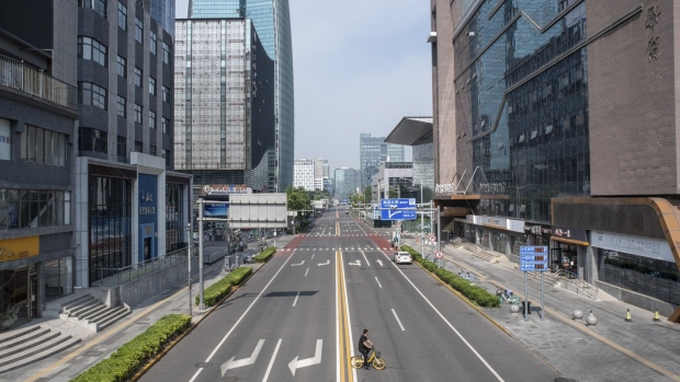A cyclist rides across a near-empty road in Beijing, China, on Monday, May 23, 2022. Beijing reported a record number of Covid cases during its current outbreak, reviving concern the capital may face a lockdown as authorities seek to stamp out community spread of the virus.