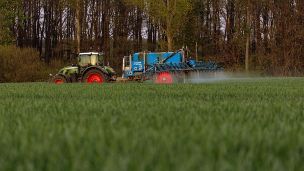 A tractor pulls a Lemken Gmbh Albatros trailed sprayer through a field of grain in Brandenburg, Germany, on Monday, May 2, 2022. Access to edible oils for making food, biofuels and personal care products is increasingly at risk as war in Ukraine and weather-driven supply woes crimps both supply and trade flow. Photographer: Krisztian Bocsi/Bloomberg
