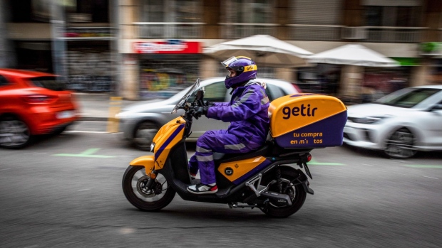 A courier for the food delivery service Getir, operated by Getir Perakende Lojistik AS, rides along a street in Barcelona, Spain, on Saturday, Feb. 12, 2022. The Istanbul-based company, which raised $1.1 billion in total through several rounds from investors last year, has grown to become one of the most valuable rapid delivery startups.