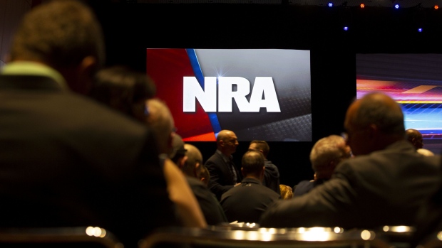 An National Rifle Association (NRA) logo is displayed above members during the NRA annual meeting of members in Indianapolis, Indiana, U.S., on Saturday, April 27, 2019. Retired U.S. Marine Corps Lieutenant Colonel Oliver North has announced that he will not serve a second term as the president of the NRA amid inner turmoil in the gun-rights group. Photographer: Daniel Acker/Bloomberg