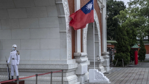 An honor guard stands next to the Taiwanese flag at the National Revolutionary Martyrs' Shrine in Taipei, Taiwan, on Tuesday, May 24, 2022. US President Joe Biden is seeking to show US resolve against China, yet an ill-timed gaffe on Taiwan risks undermining his bid to curb Beijing’s growing influence over the region. Photographer: Lam Yik Fei/Bloomberg
