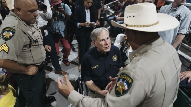 Greg Abbott, governor of Texas, speaks with sheriffs during a vigil for victims of the Robb Elementary School shooting in Uvalde, Texas, US, on Wednesday, May 25, 2022. President Joe Biden mourned the killing of at least 19 children and two teachers in a mass shooting at a Texas elementary school on Tuesday, decrying their deaths as senseless and demanding action to try to curb the violence.