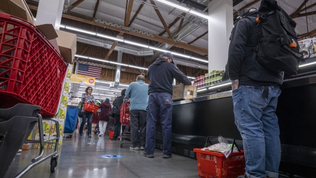 Shoppers wait in line to checkout inside a grocery store in San Francisco, California, U.S., on Monday, May 2, 2022. U.S. inflation-adjusted consumer spending rose in March despite intense price pressures, indicating households still have solid appetites and wherewithal for shopping.