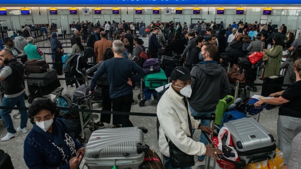 Passengers queue to check in at British Airways desks inside the departures hall of Terminal 5 at London Heathrow Airport in London, U.K., on Wednesday, April 13, 2022. Travel disruption continued to hit U.K. holidaymakers as officials warned of expected queues at airports later in the week and motorists faced fuel shortages.