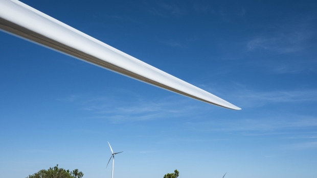 A newly attached propeller blade sits on a wind turbine tower operated by EDP-Energias de Portugal SA's renewables unit, EDP Renovaveis SA in Maunca, Portugal, on Monday, June 18, 2018. France’s Engie SA is among suitors considering a bid for the 7.3 billion-euro ($8.5 billion) renewables unit of EDP-Energias de Portugal SA, according to people with knowledge of the matter, adding a potential new twist to China Three Gorges Corp.’s pursuit of the company and its parent. Photographer: Daniel Rodrigues/Bloomberg