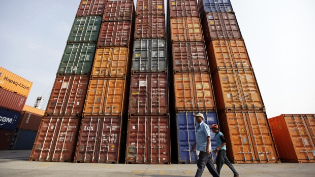 Dock workers walk past stacked shipping containers at the Tanjung Priok port in Jakarta. The current-account gap in Southeast Asia’s largest economy swelled to a record $9.8 billion, or 4.4 percent of gross domestic product, in the second quarter, Bank Indonesia data showed on Aug. 16.