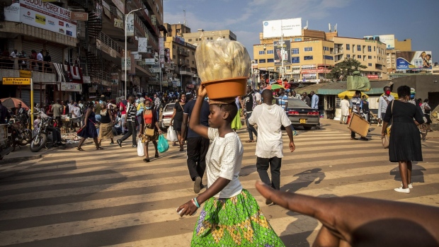 A girl carries corn husks on her head in Kampala, Uganda, on Thursday, July 23, 2020. Uganda's economy will probably expand at the slowest pace in more than three decades this year due to the fallout from the coronavirus pandemic, a locust invasion and floods, the World Bank said.