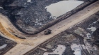 A heavy hauler truck drives through the Suncor Energy Inc. Millennium mine in this aerial photograph taken above the Athabasca oil sands near Fort McMurray, Alberta, Canada, on Monday, Sept. 10, 2018. While the upfront spending on a mine tends to be costlier than developing more common oil-sands wells, their decades-long lifespans can make them lucrative in the future for companies willing to wait.