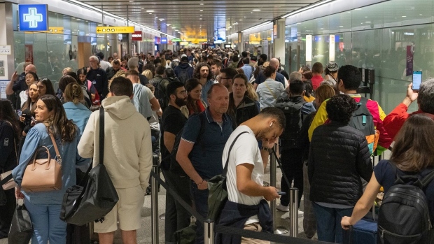 Travellers wait in a long queue to pass through the security check at Heathrow in London on June 1, 2022.