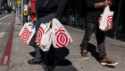 Shoppers carry Target shopping bags in front of a store in San Francisco, California, US, on Tuesday, May 10, 2022. Target Corp. is scheduled to release earnings figures on May 18.