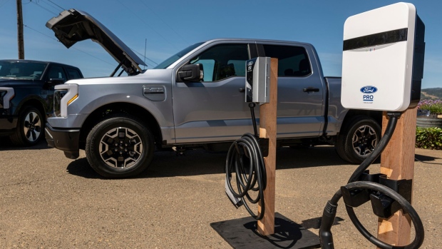 A Ford Lightning F-150 pickup truck next to a charging station during a media event at Vino Farms in Healdsburg, California, US, on Friday, May 20, 2022. With the release of the F-150 Lightning, Ford hopes to electrify new and traditional truck buyers alike, and eventually to replace its industry-defining gas-powered line.