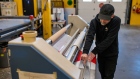 A worker laminates stop signs at the Tran Sign manufacturing facility in Langford, British Columbia, Canada, on Wednesday, May 18, 2022. Tran Sign supplies signage to the B.C. government, as well as municipalities, and private companies around Vancouver Island and across the province.
