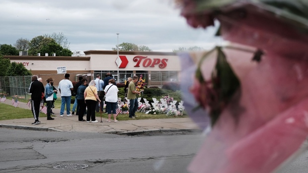 People gather at a memorial for the shooting victims outside of Tops grocery store on May 20, 2022 in Buffalo, New York.