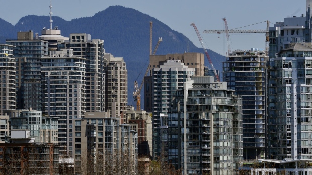 Cranes stand over residential buildings in Vancouver, British Columbia, Canada, on Thursday, April 16, 2020. As its oil sector shriveled in recent years, Canada's economy became ever more driven by real estate, an industry now in a state of paralysis while its households are among the world's most indebted, poorly placed to weather the storm. Photographer: Jennifer Gauthier/Bloomberg