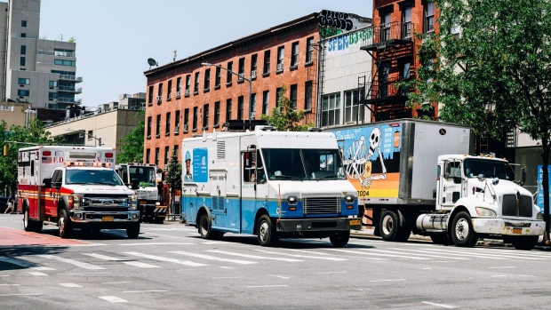 An ambulance passes a Con Edison van during a heatwave in the East Village neighborhood of New York, U.S., on Tuesday, June 29, 2021. The East Coast heat wave will be different from the Northwest's because it will reverse in coming days, with rain and a high of just 77 forecast for New York Friday.