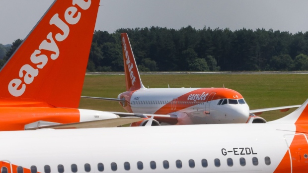An Easyjet Plc aircraft taxis along the tarmac at London Luton Airport in Luton, U.K., on Monday, July 19, 2021. While fully vaccinated tourists headed for the Mediterranean were cheered by the removal of quarantine requirements on their return, people bound for France hit out a decision late Friday that means they’ll still need to self-isolate.