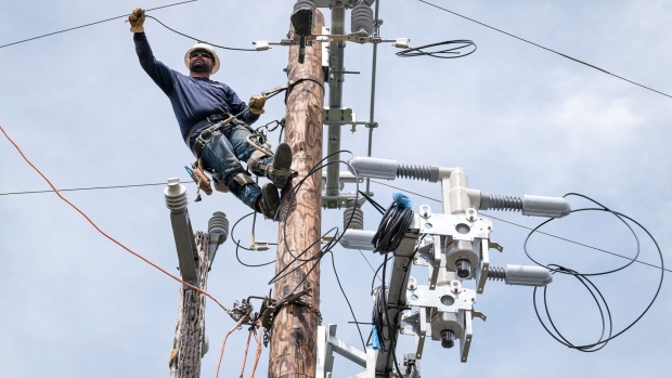 A Pacific Gas & Electric Co. worker moves a wire into place while installing a bypass switch in Yountville, California in April 2020. 