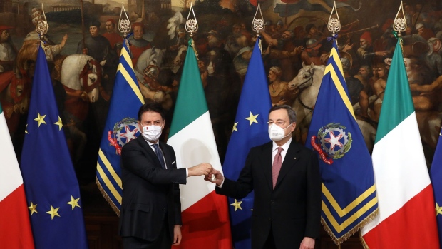Giuseppe Conte, Italy's outgoing prime minister, left, hands a bell to Mario Draghi, Italy's incoming prime minister, during a handover ceremony at Chigi Palace in Rome, Italy, on Saturday, Feb. 13, 2021. Italys Mario Draghi unveiled his long-awaited government that includes Bank of Italys Daniele Franco as finance minister and taps a state-owned defense company executive for a green job.