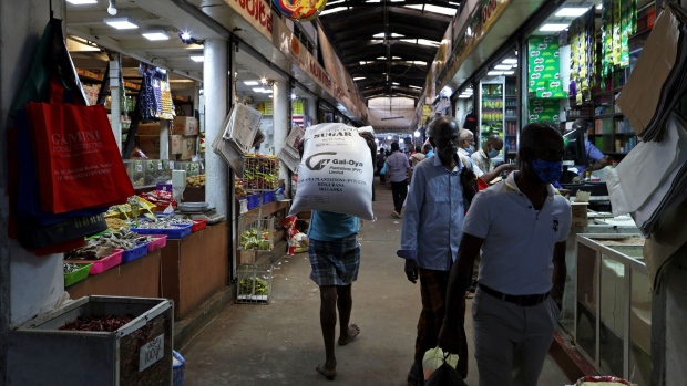A worker carries a sack of sugar in a market in Kandy, Sri Lanka, on Monday, June 13, 2022. Sri Lanka’s economy is likely contracted in the first quarter, slammed by public protests, political instability, high commodity prices, power shortages and supply-chain snarls.