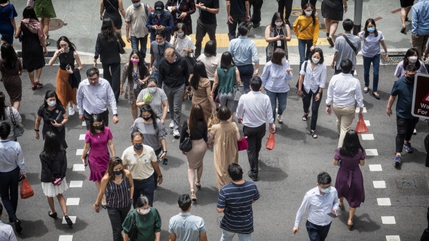 Pedestrians in the central business district in Singapore, on Tuesday, April 26, 2022. Singapore began allowing all workers to return to the workplace and doing away with checking people’s vaccination statuses at most places. Photographer: Bryan van der Beek/Bloomberg