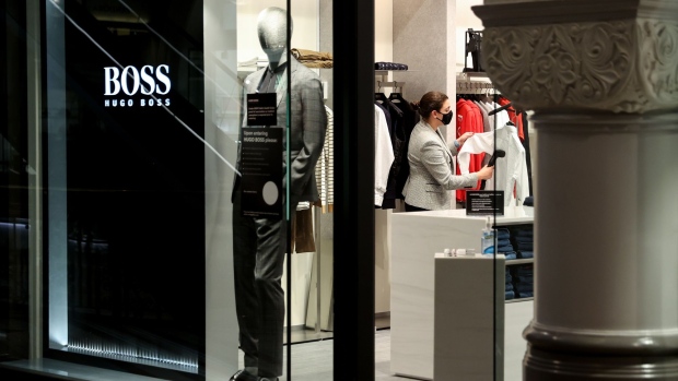 An employee steams a piece of clothing inside a Hugo Boss store prior to opening in the Queen Victoria Building in Sydney, Australia, on Monday, Oct. 11, 2021. Residents of New South Wales who have received both doses of the covid vaccine were on Monday again allowed to start visiting non-essential retail stores, pubs and gyms, with capacity limits. The government eased lockdown measures once 70% of people over age 16 were fully vaccinated.