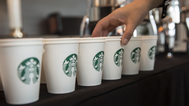 The Starbucks Corp. logo is displayed on paper cups. 