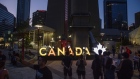 Visitors gather near an illuminated Canada sign outside the CN Tower in Toronto, Ontario, Canada, on Sunday, Aug. 4, 2019. Canada is scheduled to release gross domestic product (GDP) figures on August 30. Photographer: Brent Lewin/Bloomberg