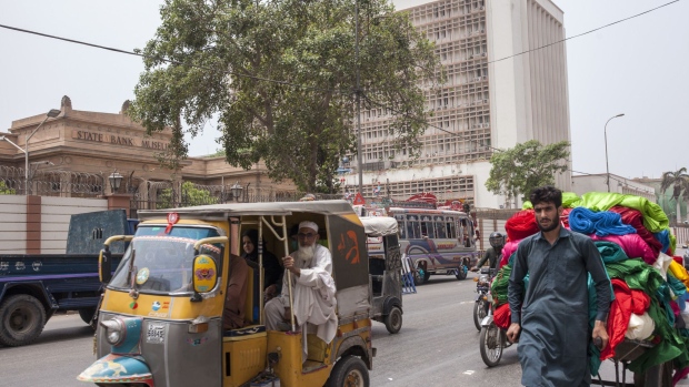 Traffic moves past the State Bank of Pakistan building in Karachi, Pakistan, on Thursday, July 26, 2018. Former cricket star Imran Khan was close to winning an outright majority in Pakistan’s election as his main political rivals complained of vote rigging in a contest already tarnished by violence and allegations of army interference.