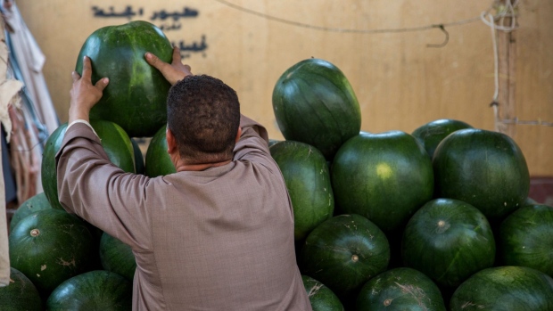 A vendor arranges a display of watermelons at the Al-Manhal market in the Nasr city district of Cairo. Photographer: Islam Safwat/Bloomberg