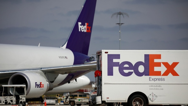 A delivery truck parked near a cargo jet during the morning package sort at the FedEx Express Hub in Memphis, Tennessee, U.S., on Tuesday, March 8, 2022. FedEx Corp. earlier had suspended inbound service to Russia, but now has halted all package movements including domestic deliveries in both Russia and Belarus, according to an employee memo.