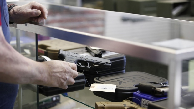 A salesperson takes a Glock handgun out of a case at a store in Orem, Utah, U.S., on Thursday, March 25, 2021. Two mass shootings in one week are giving Democrats new urgency to pass gun control legislation, but opposition from Republicans in the Senate remains the biggest obstacle to any breakthrough in the long-stalled debate. Photographer: George Frey/Bloomberg