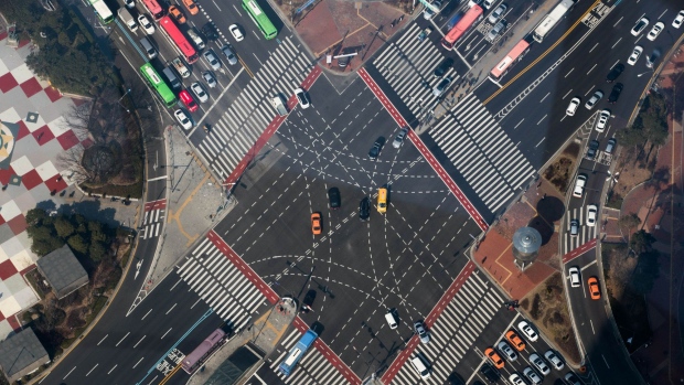Traffic moving through an intersection is seen from the glass-bottomed observation deck of the Lotte Corp. World Tower in Seoul, South Korea, on Thursday, March 16, 2017. After almost seven years of planning and 4 trillion won ($3.6 billion) in spending, Lotte Group is preparing to unwrap its tower to the public. The building boasts some record-setting amenities: highest glass floor at the top of a building and highest swimming pool. Photographer: SeongJoon Cho/Bloomberg