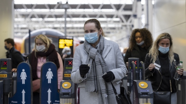City commuters wear face masks at Waterloo station in London. 