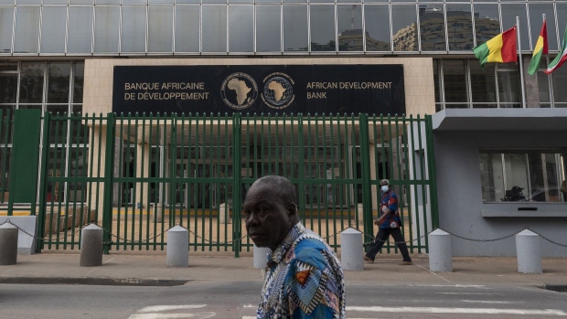 Pedestrians pass by headquarters for the African Development Bank (AfDB) in the Plateau business district of Abidjan, Ivory Coast, on Monday, May 16, 2022. Surging international food prices will hit Africa’s economies the hardest and may trigger social unrest if governments fail to cushion the blow, according to a report by Oxford Economics Africa.