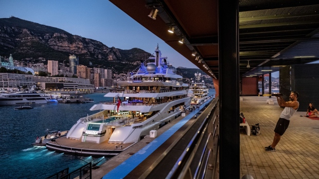 People workout in a quayside gym beside luxury superyacht Amadea, manufactured by Luerssen Verwaltungs GmbH, at night ahead of the Monaco Yacht Show (MYS) in Port Hercules, Monaco, on Tuesday, Sept. 24, 2019. The MYS features 125 luxury superyachts and runs from Sept. 25 - 28.