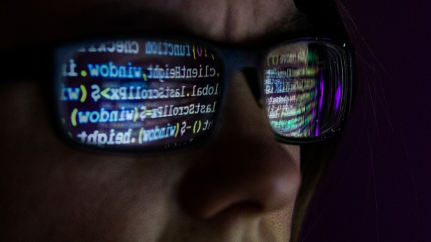 Computer code reflected in glasses arranged in Danbury, U.K., on Wednesday, Dec. 30, 2020. In the spring, hackers managed to insert malicious code into a software product from an IT provider called SolarWinds Corp., whose client list includes 300,000 institutions.