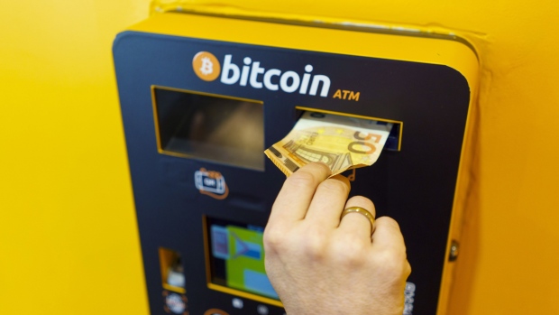 A customer deposits a 50 euro banknote into a Bitcoin automated teller machine (ATM), operated by BitBase, inside a cryptocurrency exchange in Madrid, Spain, on Thursday, March 17, 2022. Bitcoin edged higher following reassurance from Federal Reserve Chairman Jerome Powell that the U.S. economy was strong enough to weather tightening monetary policy. Photographer: Angel Navarrete/Bloomberg