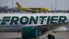 A Frontier Airlines airplane taxis past a Spirit Airlines aircraft at Indianapolis International Airport in Indianapolis, Indiana, U.S., on Monday, Feb. 7, 2022. Frontier Group Holdings Inc. agreed to buy Spirit Airlines Inc. for $2.9 billion in cash and stock, uniting two ultra-low-cost carriers targeting the recovering U.S. leisure-travel market. Spirit shares rose the most in 14 months.