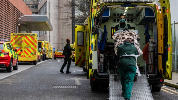 Paramedics unload a patient from an ambulance outside the Royal London Hospital in London, U.K., on Friday, Jan. 7, 2022. The U.K. sent 200 armed forces personnel into hospitals in London to help relieve staff shortages due to a surge in the omicron Covid-19 variant. Photographer: Chris J. Ratcliffe/Bloomberg