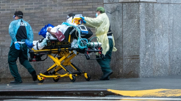 EMS workers transport a patient on the side walk outside of Mount Sinai hospital on April 13, 2020 in New York City.