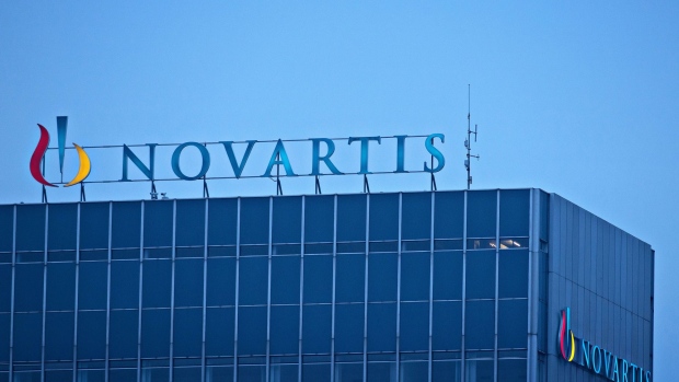 The Novartis AG Logo sits on top of the company's headquarters office in Basel, Switzerland, on Wednesday, Jan. 25, 2017. Novartis proposed buying back $5 billion of shares and said it's considering separating its embattled eye-care division after projecting that sales this year at Europe's second-biggest drugmaker will likely be largely unchanged from 2016. Photographer: Michele Limina/Bloomberg