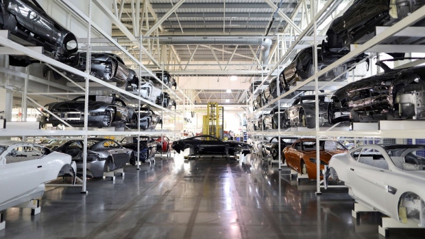 The painted bodywork of an Aston Martin DB11 luxury automobile is moved by a robot through the Aston Martin Lagonda Ltd.'s manufacturing and assembly plant in Gaydon, U.K., on Tuesday, June 6, 2017. Aston Martin may consider an initial public offering as early as next year as the British maker of James Bond’s cars seeks to capitalize on the success of Ferrari NV’s listing to lure investors, people familiar with the matter said.