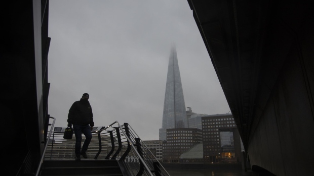 A commuter walks down steps in view of The Shard in the City of London, U.K., on Monday, Feb. 15, 2021. The U.K. recorded 15 million vaccinations against the coronavirus, a milestone that is set to increase pressure on Prime Minister Boris Johnson to begin reopening the economy. Photographer: Jason Alden/Bloomberg