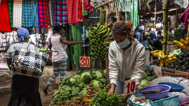A vendor wearing a protective face mask arranges fresh produce on her vegetable stall at Toi market in Nairobi, Kenya, on Tuesday, May 26, 2020. Kenya plans to spend 53.7 billion shillings ($503 million) on a stimulus package to support businesses that have been hit by the coronavirus pandemic, according to the National Treasury.