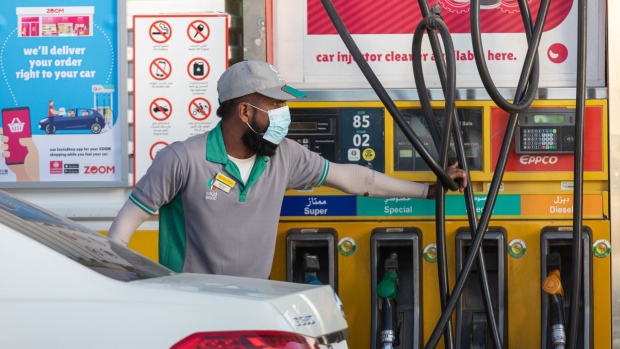 An attendant wears a protective face mask while using a fuel pump at an Eppco, also known as Emirates Petroleum Product Co., gas station in Dubai, United Arab Emirates, on Tuesday, March 10, 2020. The Middle Easts travel and business hub called on citizens and residents to avoid travel due to the coronavirus risk.