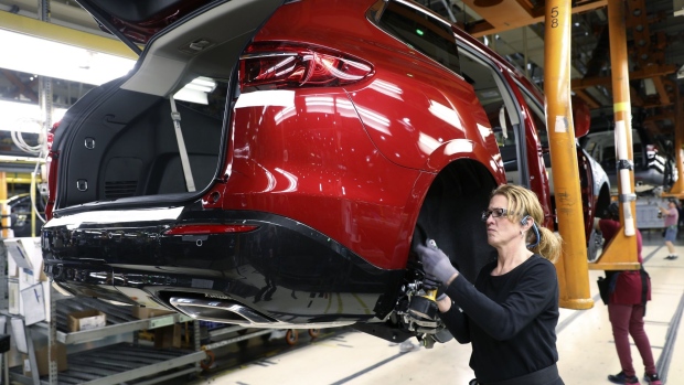 An employee installs components on a vehicle at the General Motors Co. Lansing Delta Township Assembly Plant in Lansing, Michigan, U.S., on Friday, Feb. 21, 2020. The plant started production in 2006 and employs over 2,500 workers over two shifts.