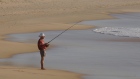 An elderly man fishes from the beach in Sydney. Australia’s do-it-yourself pension plans are unique among developed nations.