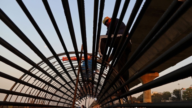 Workers labor on reinforcing steel at a flyover construction site in Patna, Bihar, India, on Thursday, Feb. 25, 2021. After falling into a coronavirus-fueled recession in the third quarter, India's economy has likely returned to expansion in the three months ended December, according to the median estimate in a Bloomberg survey of economists.