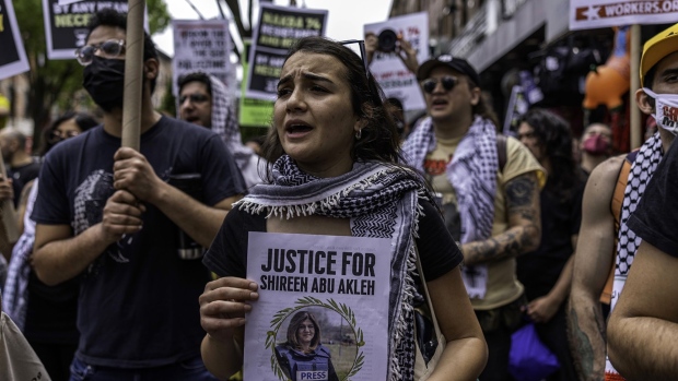 A protestor holds photo of slain Palestinian journalist Shireen Abu Akleh.